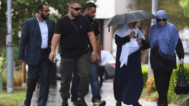 Maha Al-Shennag (with umbrella), who allegedly drove into Banksia Road Public School killing two students, arrives at Bankstown Local Court in Sydney with a group of supporters on Wednesday. Photo: AAP