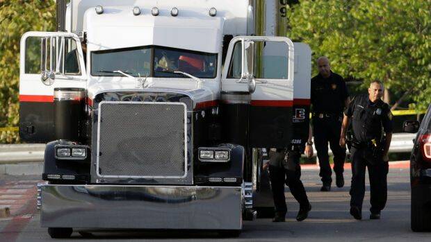San Antonio police officers investigate the tractor-trailer where the gruesome discovery was made. Photo: Eric Gray