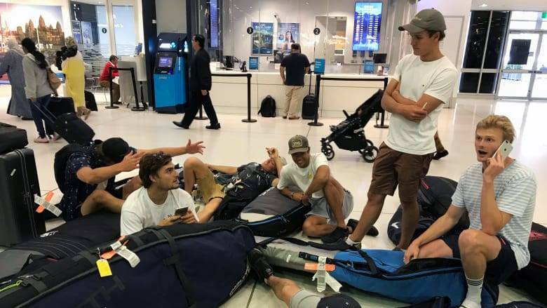 A group of surfers from Sydney wait for updates on their cancelled flight. Picture: AAP