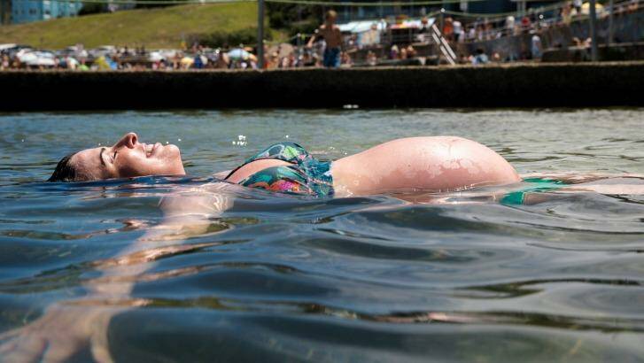 Pregnant Kate Topham takes relief from the hot weather in the rock pool in North Bondi. Photo: Edwina Pickles