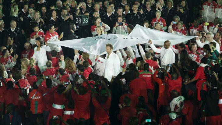 Ian Thorpe carries the Commonwealth Games flag. Photo: James Brickwood