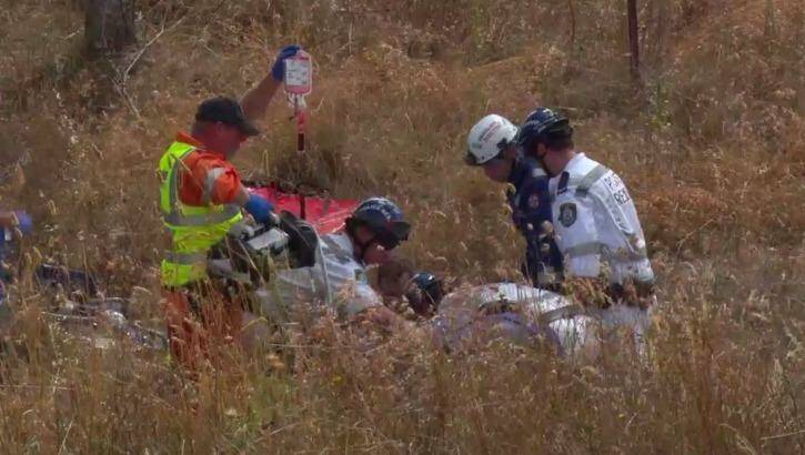 Emergency services treat Ms Jones after she was pulled from her car. Photo: TNV
