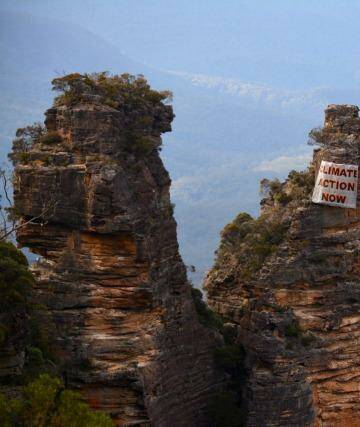 Human intervention: a banner hangs off the Three Sisters on Sunday. Photo: Ireni Clarke