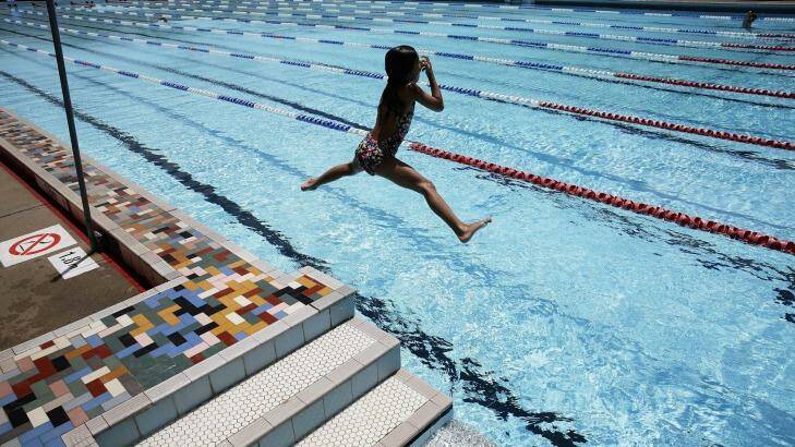 Into the blue: A young girl jumps into the pool at the Ruth Everuss Aquatic Centre in Lindcombe. Photo: Jessica Hromas