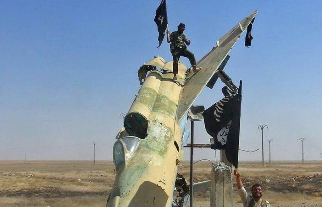 Flag waving: Islamic State fighters waving the group's flag from a damaged display of a government fighter jet following the battle for the Tabqa air base, in Raqqa, Syria. Photo: Raqqa Media Centre of the Islamic State