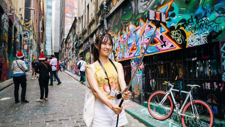 A tourists captures the moment in Hosier Lane using the popular Selfie Stick.  Photo: Greg Briggs
