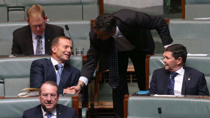 Backbencher Tony Abbott is welcomed by Darren Chester during question time at Parliament House. Photo: Andrew Meares