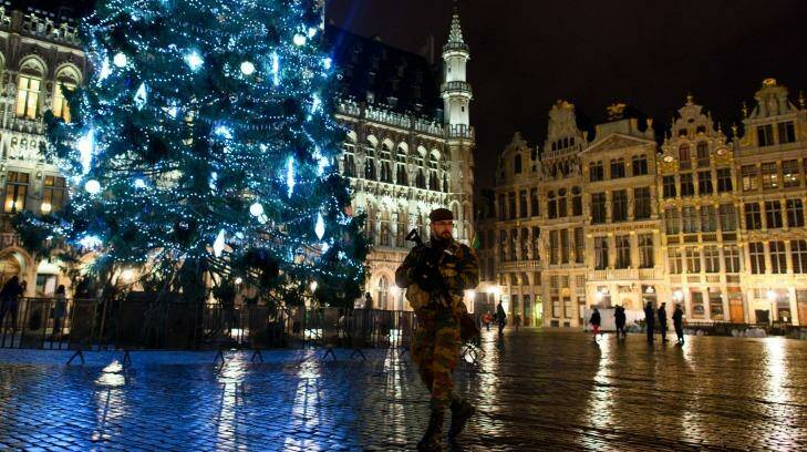 An armed soldier stands guard over the Grote Markt in Brussels on Monday. Security has been tightened in the nation's capital after police arrested 16 suspected terrorists during more than 22 anti-terror raids around the city on Sunday. Photo: Ben Pruchnie