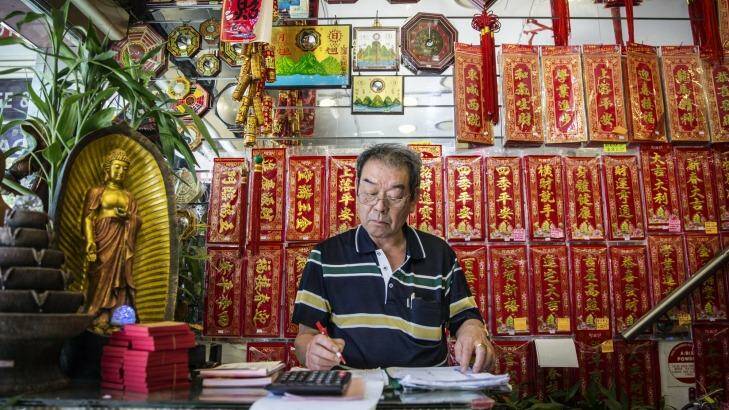 Despite Year of the Monkey celebrations it is stocktake business as usual at Leung Wai Kee Buddhist Craft and Joss Stick Trading Co, where Chinese calligraphy is just one of the gems being touted during festivities. Photo: Brook Mitchell