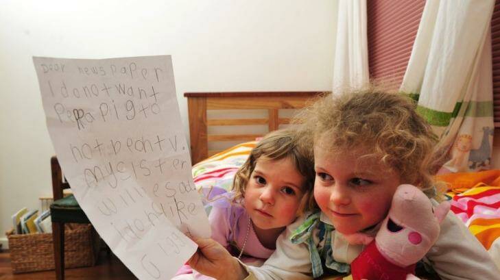 Peppa Pig fan Tess Coventry, 5, with the letter she wrote calling for the popular children's TV show to stay on the ABC for her sister India, 2. Photo: Melissa Adams