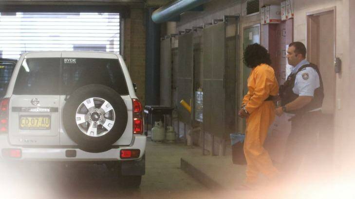 Ahmed Saiyer Naizmand is led out of Burwood Local Court in shackles after his arrest in February.  Photo: Peter Rae