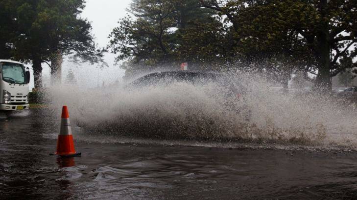 Motorists drive through the flood at New South Head Road in Rose Bay, Sydney, during the storm. Photo: Janie Barrett