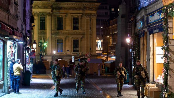 Armed soldiers patrol along Rue des Sols in Brussels on Monday. Photo: Ben Pruchnie