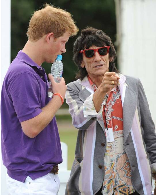 Prince Harry chats to Ronnie Wood while he shows how to affect cool in bright red frames.