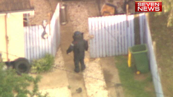 A member of the bomb squad approaches the property at the house on Dampier Street, Leichhardt, where earlier several teenagers were injured in an explosion. Photo: Courtesy Channel 7